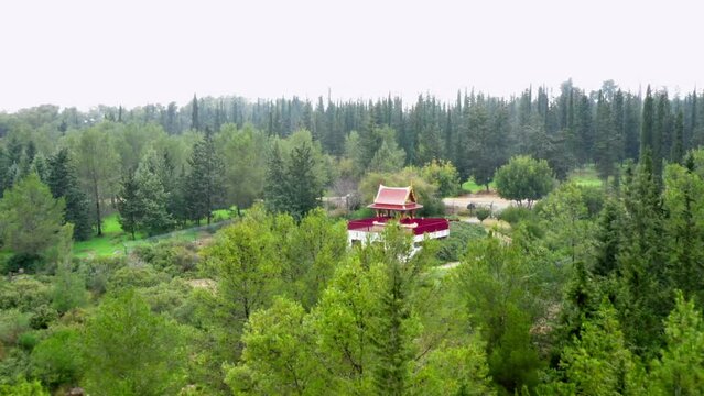 Aerial Shot Of The Thai Pagoda In Ben Shemen Forest, Drone Flying Forward Over Green Trees