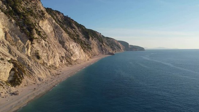 Drone shot of beautiful scenic beach with white sand and blue sea water, sunset, sunrise. Greece, Egremni beach of Lefkada island.