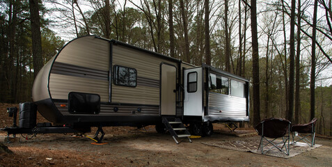 Large camping trailer in a forested campsite in North Carolina