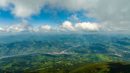 Aerial view from the mountains to a small village from the clouds