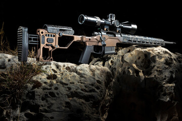 Precision rifle on rocks with black behind
