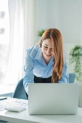 Asian businesswoman working on laptop computer in office with documents on desk woman looking at financial statistics data analysis chart profit growth business idea vertical image