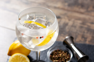 Gin tonic cocktail drink into a glass on wooden table	
