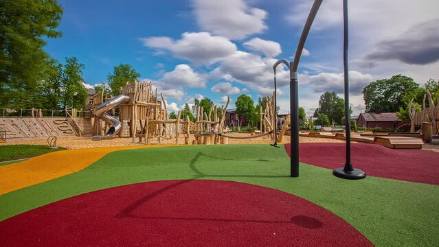Static shot of colorful playground floor along with wooden play equipment in an outdoor playground at daytime in timelapse.