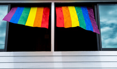 LGBTQ rainbow flag hanging on window , pride month concept