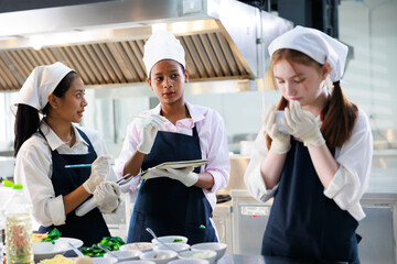 take note on book. Cooking class. culinary classroom. group of happy young woman multi-ethnic students are focusing on cooking lessons in a cooking school.