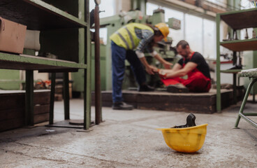 Fototapeta na wymiar Woman is helping her colleague after accident in factory. First aid support on workplace concept.