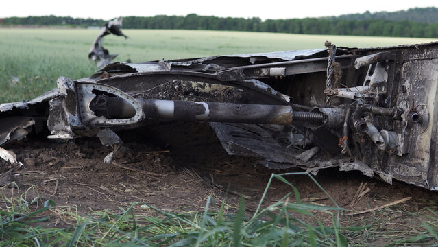 Downed military transport aircraft. Russian aggression in Ukraine. The remains of a burned-out aircraft on the field.