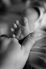 mother's hand holding baby's foot