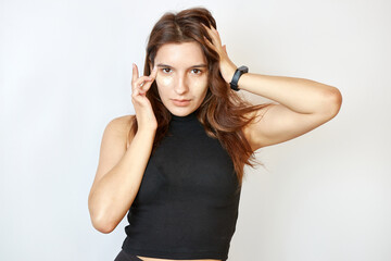 Naklejka premium Beautiful girl applies foundation on her face.
