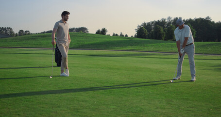Obraz premium Golfing team play sport on course. Golf group practicing hits in country club.