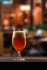 Tulip glass of beer on counter in pub.