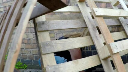 A scared running woman hides. The girl has blond hair and is hiding from a pursuer who is giving chase.