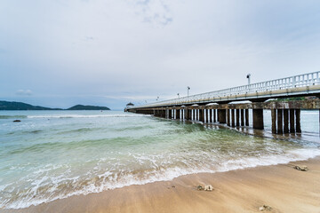 Side view of pier at the beach at sunset time.Thailand.