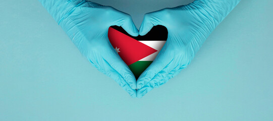 Doctors hands wearing blue surgical gloves making hear shape symbol with jordan flag