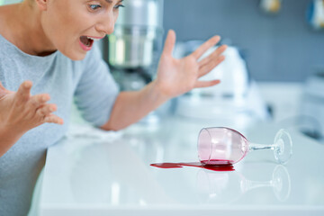 Young woman and spilled wine in the kitchen