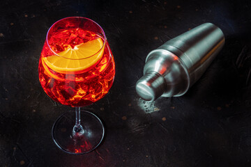 Aperol cocktail with a fresh orange slice, Italian summer cold drink on a black slate background...