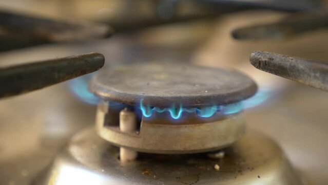 Old rusty kitchen gas oven top burner stove, fire starting.