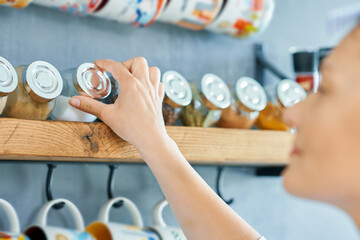 Young woman looking for spices in the kitchen