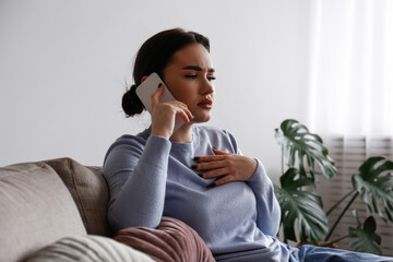 Portrait of upset young woman on the phone with a doctor receiving bad news. Sad female frowning,...