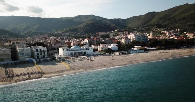Drone view of the Mediterranean with a sandy beach, town, and mountains. aerial view