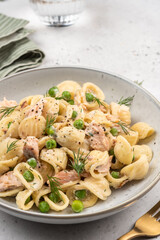 Orecchiette pasta with smoked salmon, green peas, creamy sauce and dill. Healthy food.