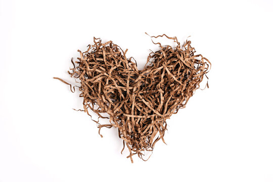 Brown heart shaped shredded paper packaging material on white background.