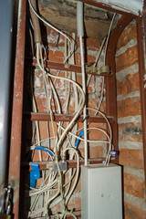 Electric cabinet with Internet and television cables in an apartment building. Niche for wires and cables inside the brick wall. Selective focus