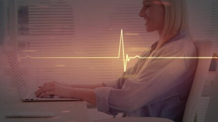 Animation of cardiograph over caucasian businesswoman using laptop - Powered by Adobe