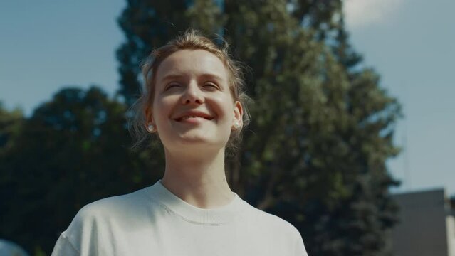 Portrait woman standing waving in sunlight outdoors. Closeup lady see friend off