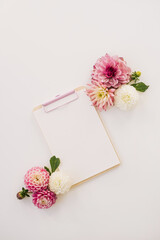 Blank paper sheet tablet pad with mockup copy space and flower buds