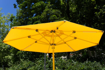 Close-up of yellow sunshade at park at City of Zürich on a blue cloudy spring day. Photo taken May 30th, 2022, Zurich, Switzerland.