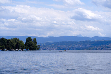 Scenic view over Lake Zürich at City of Zürich with mountains in the background on a blue cloudy spring day. Photo taken May 30th, 2022, Zurich, Switzerland.