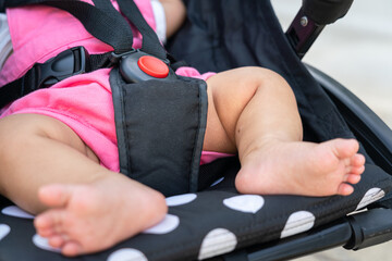 Close-up at belt locking safety button on the baby body of the baby stroller wheel. Transportation device and equipment object photo.