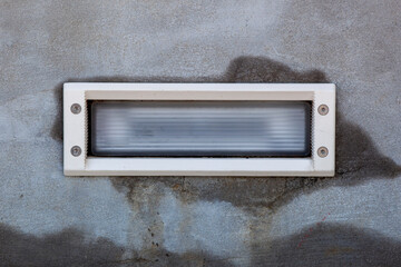 Fixed stair light embedded in concert with a white frame.. Photographer Derek Broussard