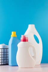 Different bottles with washing gel on a blue background. The concept of laundry, washing, household chemicals. 