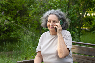 Elderly woman with gray hair talking on the phone