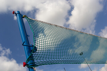 Tennis or volleyball net against blue sky. Beautiful cirrus clouds. Beautiful cirrus clouds over the sports field