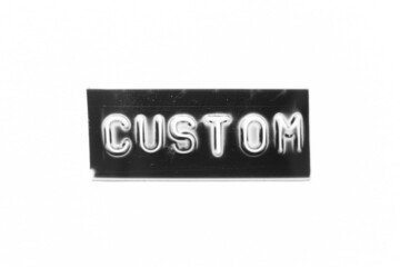 Black color banner that have embossed letter with word custom on white paper background