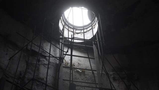 View from the underground communication to the surface through the manhole with ladder. Exit to the surface from the drainage through the manhole.