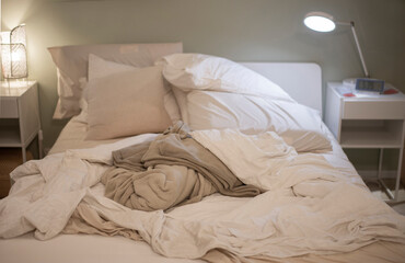 Picture of a bed with cluttered blankets