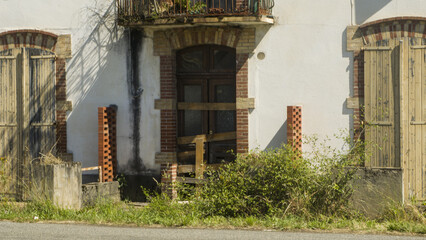 Entrée d'un vieux bâtiment en ruine ,porte en bois barricadé avec des planches. maison délabré...