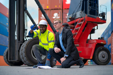 Selective focus on man with suit: The manager is listening to cargo staff explain the job details in container yard.