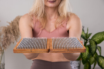 yogi woman holding sadhu board for Nail standing practice yoga meditation foot massage 