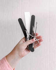 Female hands with supplies for pedicure or manicure /manicure set isolated on white background....