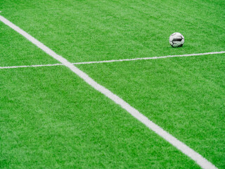 a soccer ball in the middle of the artificial grass pitch