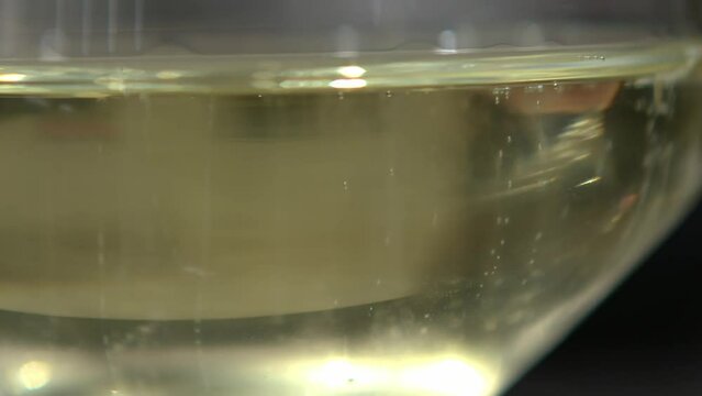 Close up of a glass of sparkling white wine, bubbles of champagne or prosecco