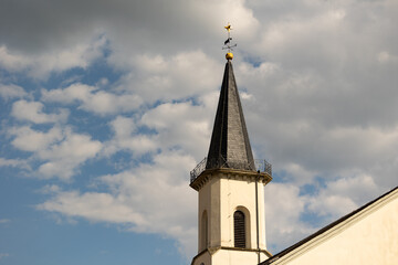 Friedrichsdorf, Hochtaunus, Hessen, Germany Mai 2022. Church tower of the Protestant church in Friedrichsdorf. Blue sky with clouds.