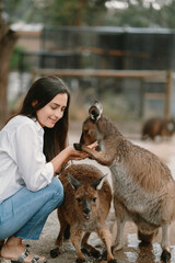 Woman in the reserve is playing with a kangaroo