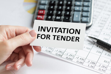 Closeup on businessman holding a card with text INVITATION FOR TENDER, business concept image with soft focus background and vintage tone